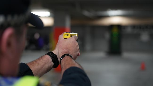 Tasmania Police Constable Paul Bennett fires a Taser weapon.