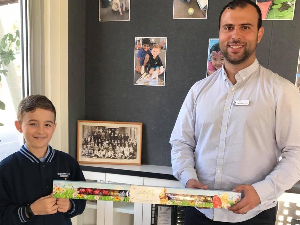 St Anthony's Primary School student Alistair Larsen with teacher Harry Georgiou. Alistair arrived at school with a giant box of chocolates for Mr Georgiou to say ‘thank you’ for keeping the students safe during the coronavirus crisis. Picture: Supplied