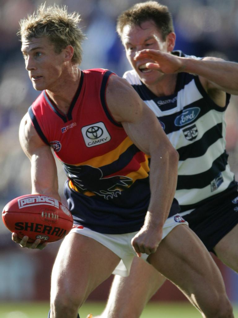 2005 - Scott Thompson handballs before Geelong’s Brenton Sanderson can tackle. Sanderson would go on to be Thommo’s coach.