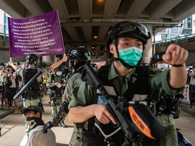 HONG KONG, CHINA - JULY 01: Riot police detain a man as they raise a warning flag during a demonstration against the new national security law on July 1, 2020 in Hong Kong, China. Hong Kong marks the 23rd anniversary of its handover to China on July 1 after Beijing imposed the new national security law. (Photo by Anthony Kwan/Getty Images)