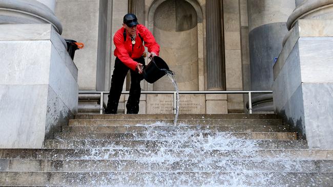 Save the Repat protestor Ki Meekins cleans the steps of Parliament House as the group packs up and leaves after 161 nights. Picture: Calum Robertson