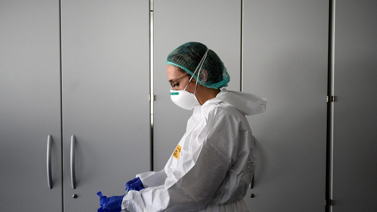 A nurse puts on her personal protective equipment in Verduno, near Alba, northwestern Italy. The virus has spread all over the world. Picture: Marco Bertorello/AFP