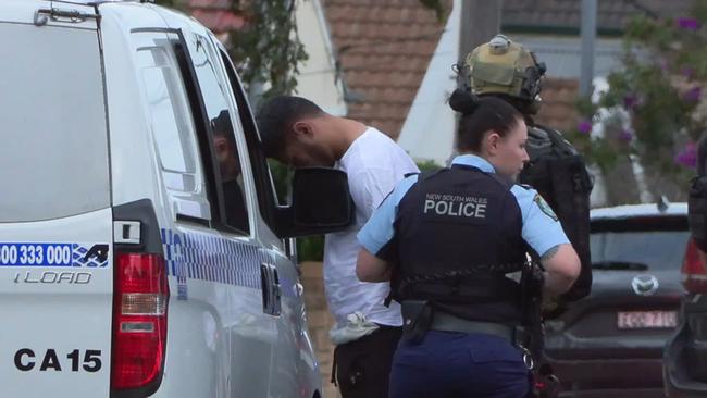 Police prepare to load a man into their van. Picture: News Media Network