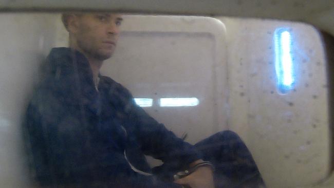 Yigit Erdogan in the back of a police wagon. Picture: Toby Zerna
