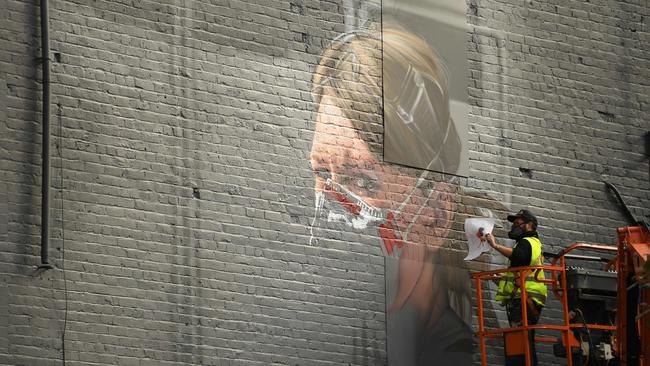 An artist creates a mural of a NHS worker on a wall in north Manchester on October 16 as the number of cases of the novel coronavirus COVID-19 rises. Picture: AFP