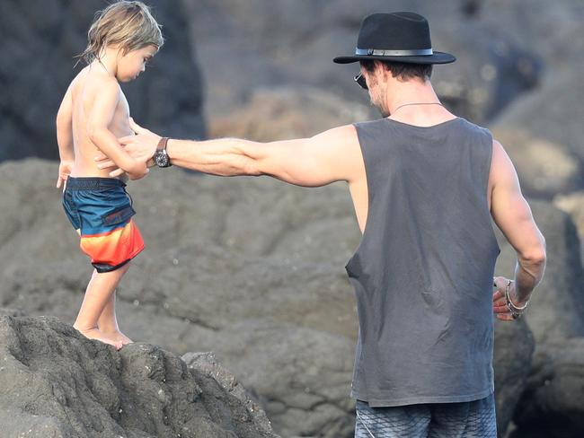 Hemsworth helps his little boy navigate the rocks. Picture: MEGA