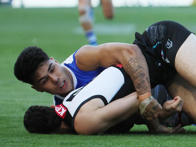 ADELAIDE, AUSTRALIA - APRIL 26: Josh Sinn of the Power is tackled by Paul Curtis of the Kangaroos during the 2025 AFL Round 07 match between the Port Adelaide Power and the North Melbourne Kangaroos at Adelaide Oval on April 26, 2025 in Adelaide, Australia. (Photo by James Elsby/AFL Photos via Getty Images)
