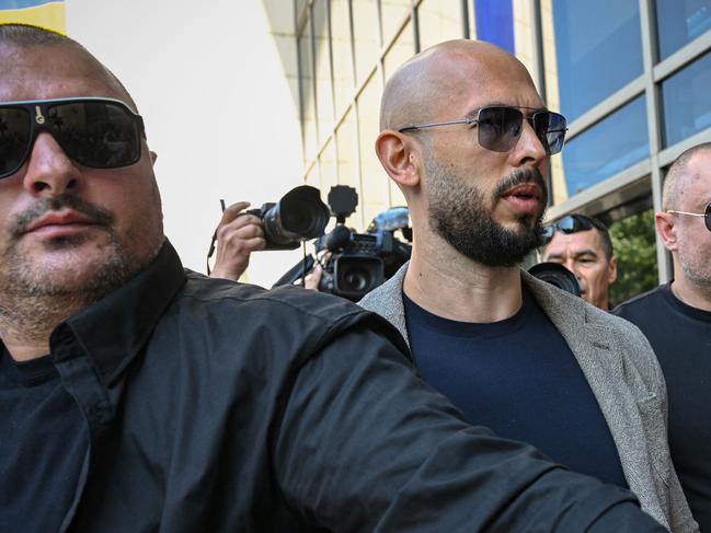 Controversial influencer Andrew Tate (C) arrives at the Municipal Court of Bucharest, Romania, on June 21, 2023. Influencer Andrew Tate, a self-described misogynist with a large online presence, was indicted in Romania on human trafficking and rape charges, officials said on June 20, 2023. Tate's brother Tristan and two Romanian women were also charged in the case, which has drawn intense international attention. (Photo by Daniel MIHAILESCU / AFP)