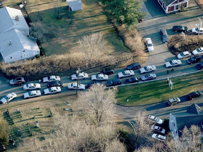 Police cars and other vehicles fill a road near the scene of Sandy Hook Elementary School in Newtown, Connecticut shortly after the mass shooting. Picture: Getty/AFP