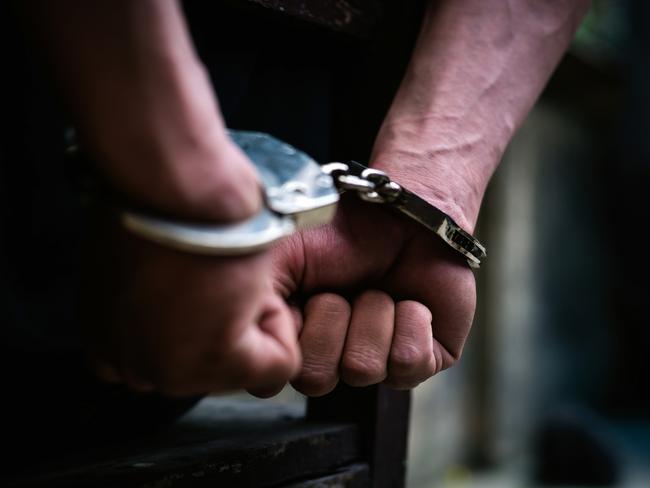 Man on the chair in Handcuffs. Rear view and Closeup ,Men criminal in handcuffs arrested for crimes. With hands in back,boy  prison shackle in the jail violence concept. - istock