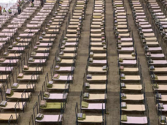 Workers set up beds at an exhibition centre that was converted into a hospital in Wuhan. Picture: AFP