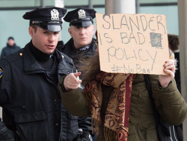 Port Authority Police Officers move a protester holding a sign at JFK International Airport's Terminal 4 to demonstrate against US President Donald Trump's executive order. Picture: AFP