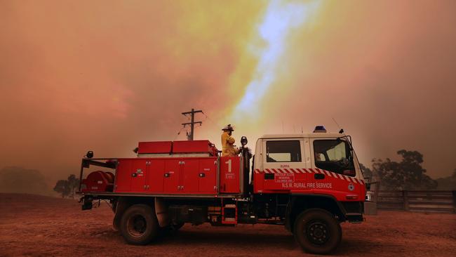 RFS volunteers from Carwoola prepare to protect property as a large fire burns out of control in the Bombay area just outside of Braidwood in NSW. Picture Gary Ramage