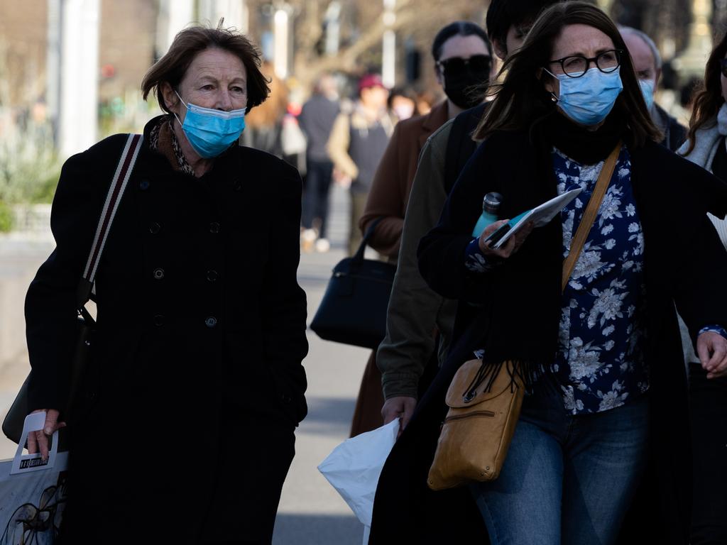 People wearing masks walk along a street in the CBD on July 11, 2022 in Melbourne, Australia. Picture: Asanka Ratnayake/Getty Images