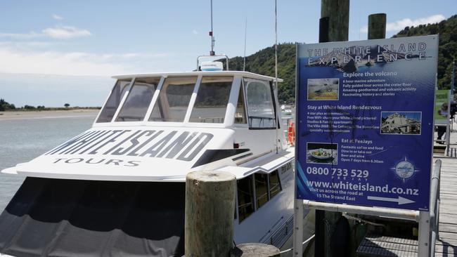 White Island Tours boat berthed in Whakatane, New Zealand next to a sign advertising the volcano experience. Picture: AAP.