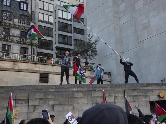 Protesters stand on top of the roof of a building at the march for ceasefire in Gaza in London. Picture: Getty Images