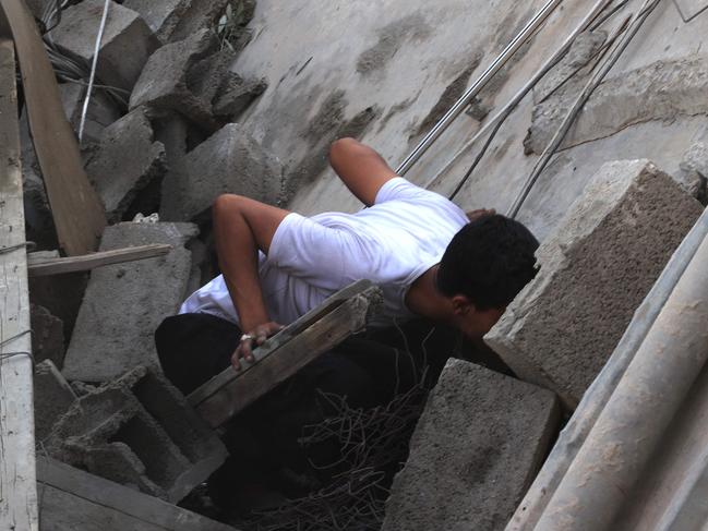 A Palestinian looks in between the collapsed concrete for a home following an Israeli air strike in Rafah, in the southern Gaza Strip. Picture: AFP