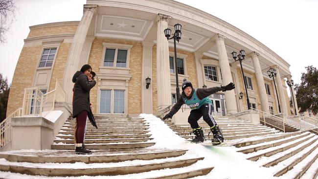 Connor Cash snowboards down the steps of a library at Texas Christian University in Fort Worth on Thursday. Picture: AFP