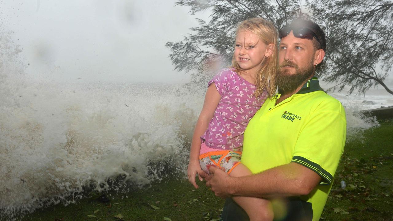 Adam Lownds and daughter Bree checking out the storm surge near the Eimeo Surf Club, during Cyclone Debbie.