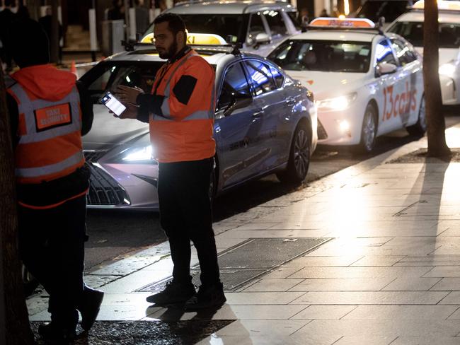 Security guards from the Point-to-Point commissioner monitoring cab ranks in the CBD on Friday night. Picture: Jeremy Piper