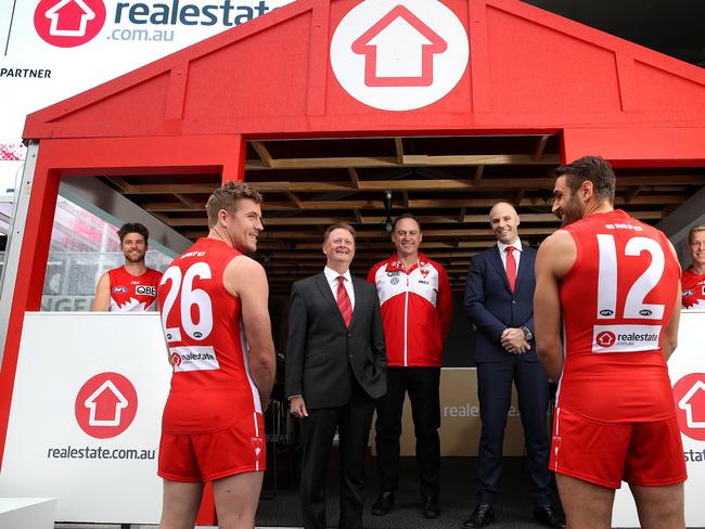 News Corp company Realestate.com.au announced as new jumper sponsor for the Swans. Pictured are Co Captains Dane Rampe, Luke Parker, Josh Kennedy and Isaac Heeney with REA Group CEO Owen Wilson, Coach John Longmire and Swans CEO Tom Harley in the Realestate.com.au house at the SCG. Picture. Phil Hillyard