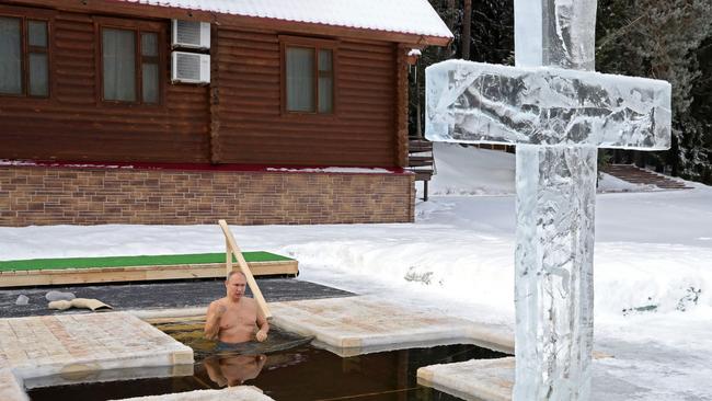 Russian President Vladimir Putin crosses himself as he plunges into the icy waters during the celebration of the Epiphany holiday on January 19. Picture: AFP