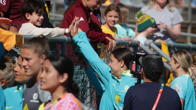 A lucky fan gets a high five from Sam Kerr before Matildas training in Brisbane on Sunday morning. Picture: Lachie Millard