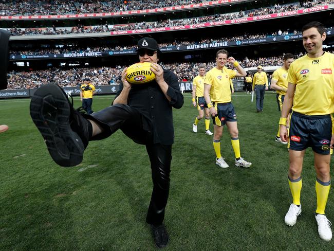 Carlton Blues fan Gene Simmons presents the match-day ball for the clash against the Collingwood Magpies at the MCG. Picture: Dylan Burns/AFL Photos via Getty Images