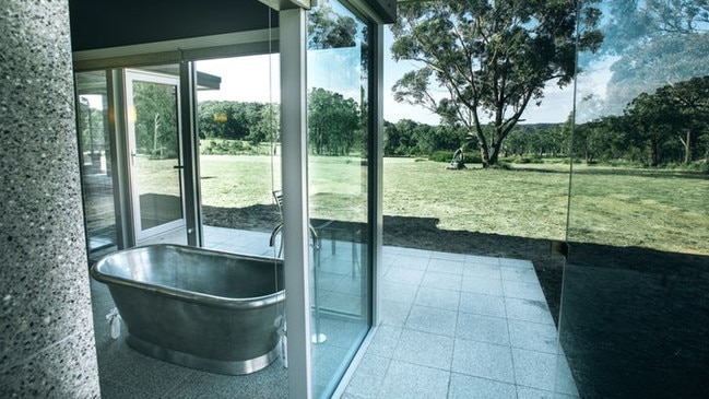 A designer bathroom surrounded by floor-to-ceiling windows in the Southern Highlands estate sold by Just Cuts founder Denis McFadden. Picture: realestate.com.au