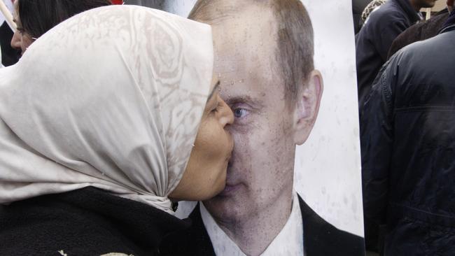 A Syrian woman kisses a poster of Russian President Vladimir Putin during a pro-Syrian government protest in 2012. Picture: AP/Muzaffar Salman