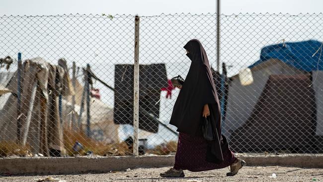 A woman walking near a fence at the Kurdish-run al-Hol camp for the displaced where families of Islamic State foreign fighters are held. Picture: AFP