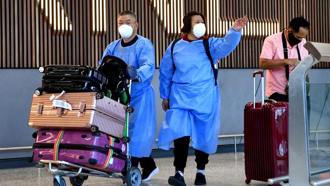 International travellers wearing PPE arrive at Melbourne Airport. Picture: AFP