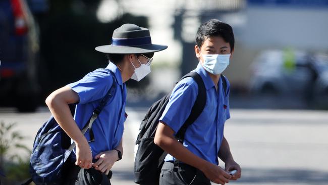 Students in masks arrive at Brisbane State High School.