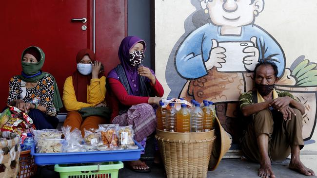 Balinese street vendors wear face masks amid fears of the coronavirus outbreak this month. Picture: AP Photo/Firdia Lisnawati.