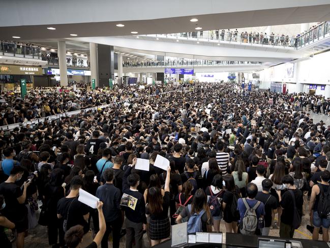 Protesters demonstrate at the airport in Hong Kong, Monday, Aug. 12, 2019. Several thousand people gathered on Monday for a fourth day of protest against a proposed extradition law at Hong Kong's busy international airport. (AP Photo/Vincent Thian)