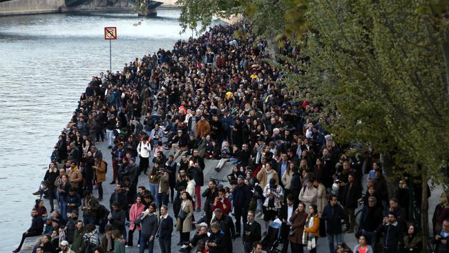 People watch as flames and smoke rise from Notre Dame as it burns. Picture: AP