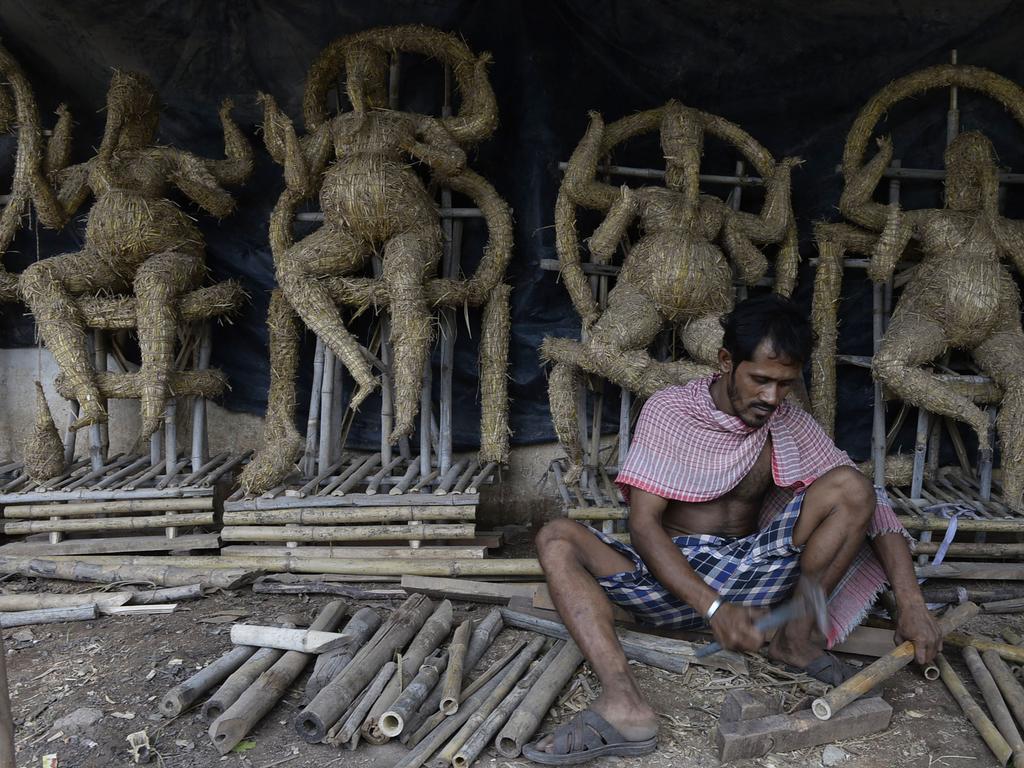 An Indian artist works on eco-friendly figures of Hindu deity Ganesh at a workshop in Hyderabad on July 18, 2018, ahead of the upcoming Ganesh Chaturthi celebrations on September 13. The eco-friendly Ganesh idols made with mud, jute fiber and bamboo are aimed at reducing pollution during the Ganesh immersion rituals. / AFP PHOTO / NOAH SEELAM
