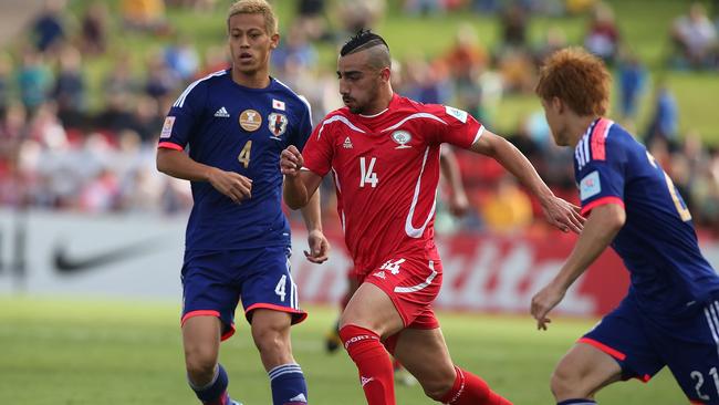 Palestine’s Abdallah Jaber runs with the ball against Japan.