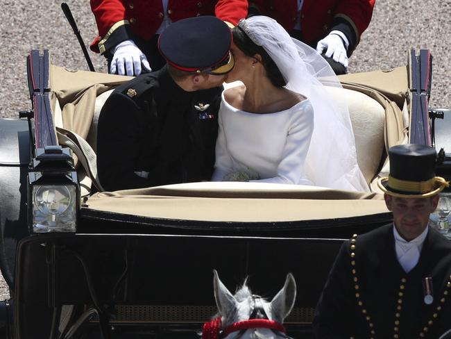 Britain's Prince Harry and Meghan Markle’s cheeky second kiss as they ride in a carriage down the Long Walk after their wedding ceremony. Picture: AP