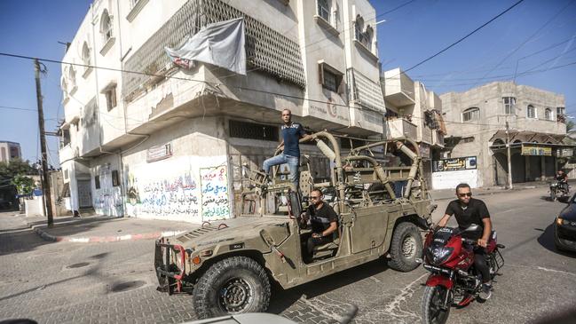 In Gaza City on Saturday, men drove an Israeli military vehicle after crossing the border fence with Israel. Picture: Zuma Press