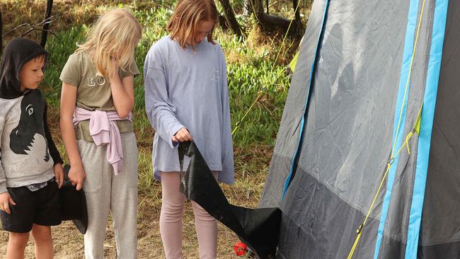 Young tourists on K’gari inspect damage caused by a dingo attacking their tent. Picture: Liam Kidston