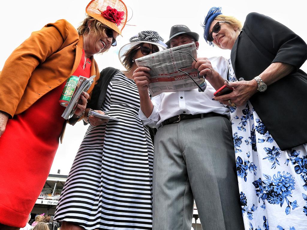 A bit of last-minute studying of the form in a bid to find the Cup winner. Picture: Tim Carrafa