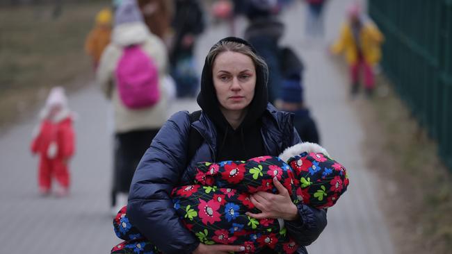 Women and children from war-torn Ukraine, including a mother carrying an infant, arrive in Poland at the Medyka border crossing on March 4. Picture: Sean Gallup/Getty Images