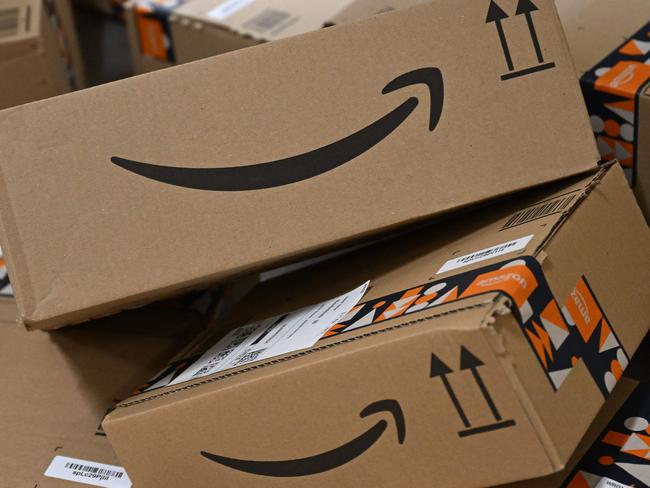 Packages with the logo of Amazon are transported at a packing station of a redistribution centre of US online retail giant Amazon in Horn-Bad Meinberg, western Germany, on December 9, 2024. (Photo by Ina FASSBENDER / AFP)