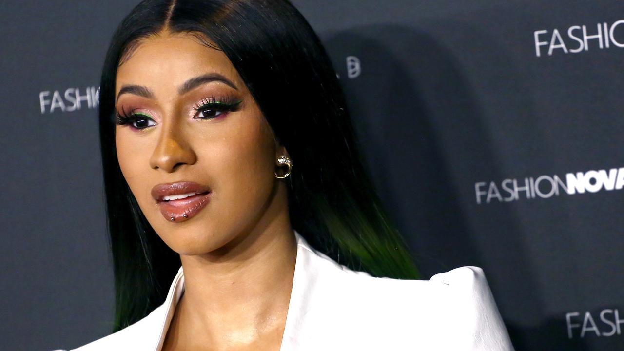 Cardi B shows off the results of her new boob job in very low cut white  suit for her fashion launch