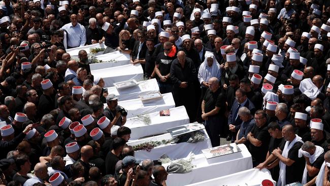 Mourners surround the coffins of those killed in a rocket strike from Lebanon, during a mass funeral in the Druze town of Majdal Shams. Picture: Jalaa Marey/AFP