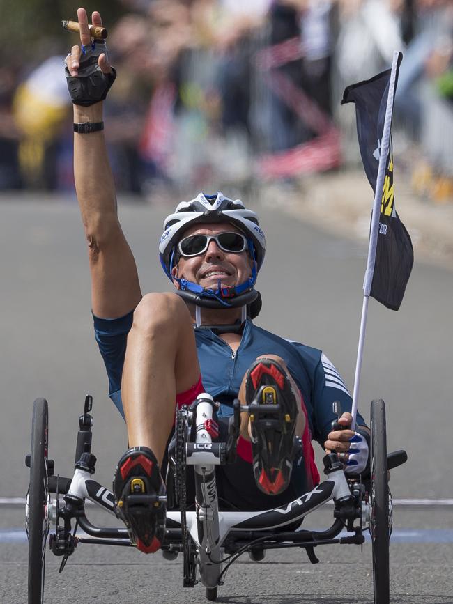 Shay Hampton of the USA crosses the finish line smoking a cigar during the Road Cycling Criterium event. Picture: AAP Image/Craig Golding