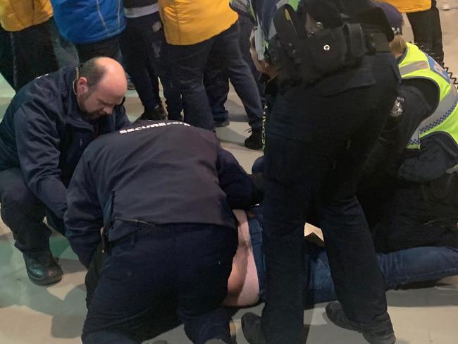 Police were forced to handcuff a man involved in a fight that erupted between footy fans at the MCG on Friday night.