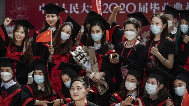 Chinese students from Renmin University of China pose for photographs after their graduation ceremony at the school's campus in Beijing, China.