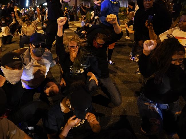 Demonstrators react as a helicopter circles low as people gather to protest the death of George Floyd near the White House in Washington. Picture: AP